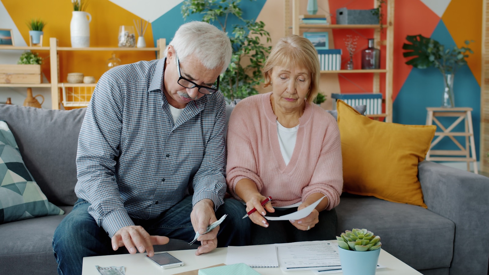 Senior homeowners reviewing property tax bills and financial documents at home